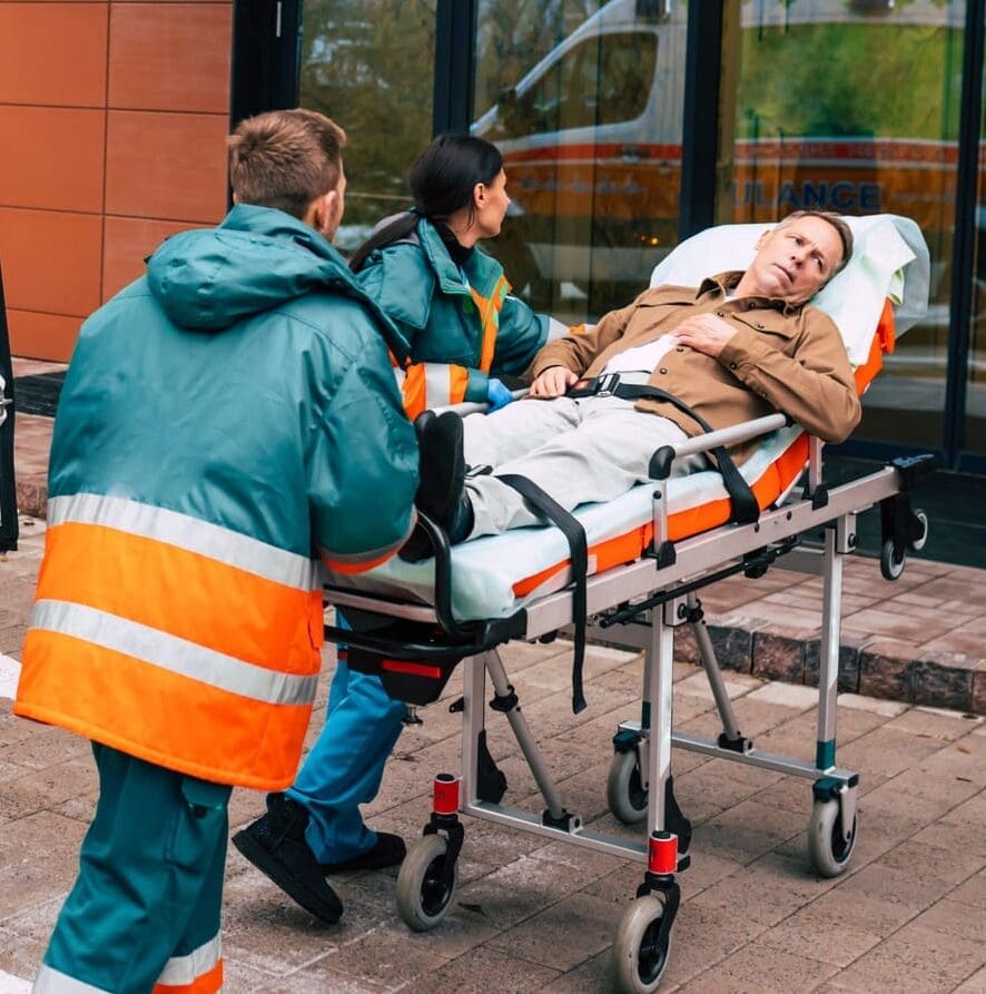Serious and professional team of doctors in the ambulance moving on a patient into the hospital during an emergency situation.
